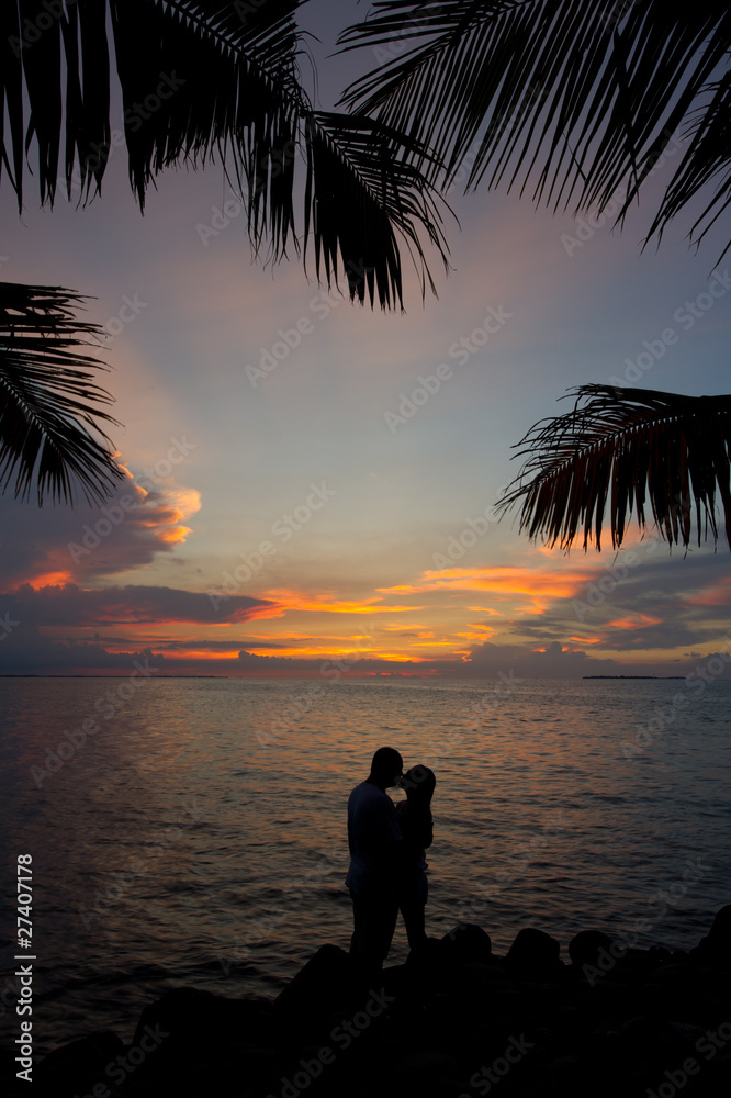romantic silhouette couple kissing in the sunset