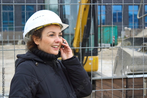Obraz na płótnie Bauleiterin telefoniert lächelnd auf einer Baustelle w salonie