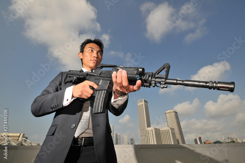 Asian Chinese Man carrying a High Powered Rifle