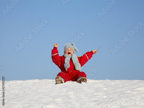 Cute blond child is playing in the snow