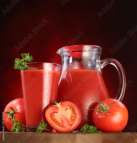 Jug and glass full of tomato juice. © volff
