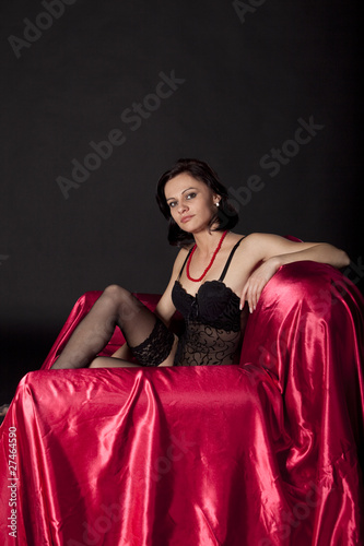 Sexy woman in black lingerie on satin bed