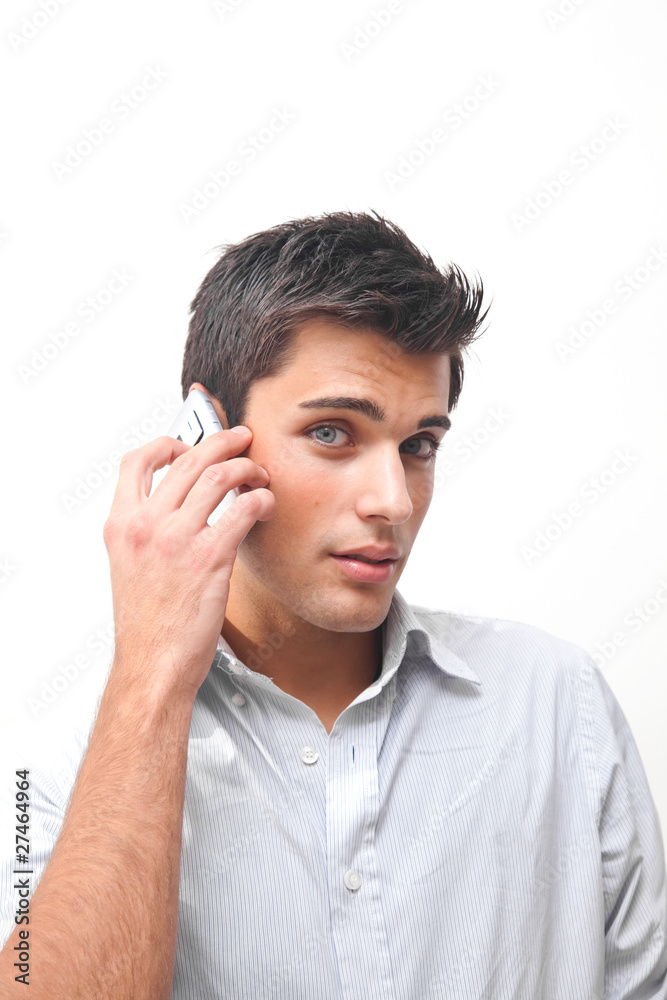 Handsome young man talking at the phone isolated on white Handsome young man talking at the phone isolated on white