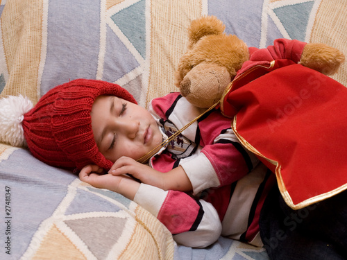 bambino che dorme nel divano con addobbi di natale photo