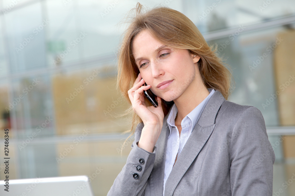 Businesswoman on the phone in front of modern building Businesswoman on the phone in front of modern building