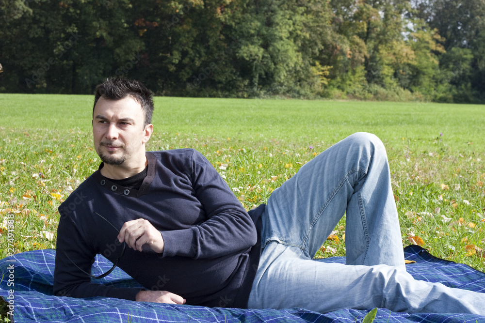 Young Adult Relaxing in the Park during a Weekend Afternoon Young Adult Relaxing in the Park during a Weekend Afternoon