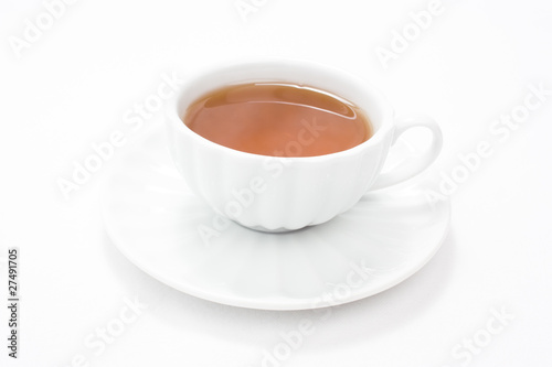 White porcelain cup with tea and saucer