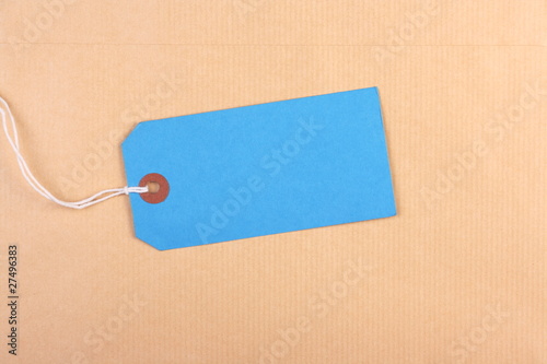 Blue paper luggage tag on brown envelope