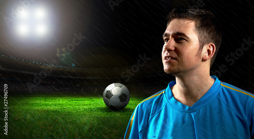 Portrait of Soccer player on the field in night rain photo