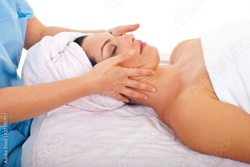 Woman relaxing with facial massage at spa