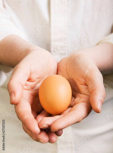 Hands holding fresh new egg