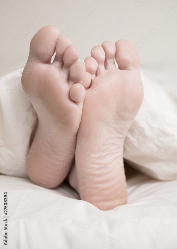 Tired and Late - Feet Sticking out of Duvet in Bed Tired and Late - Feet Sticking out of Duvet in Bed