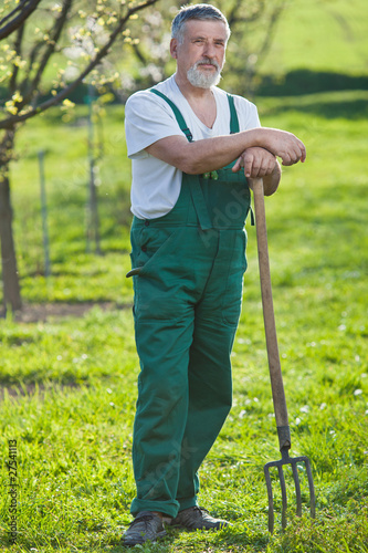 portrait of a senior man gardening in his garden