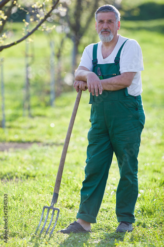 portrait of a senior man gardening in his garden