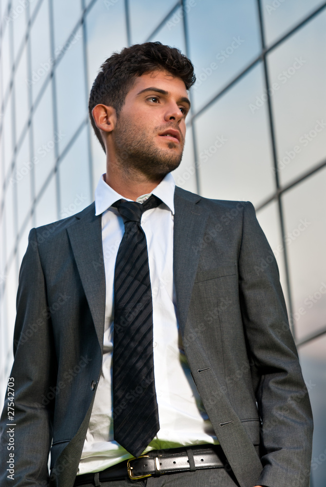 Young businessman looking to good future on modern building Young businessman looking to good future on modern building