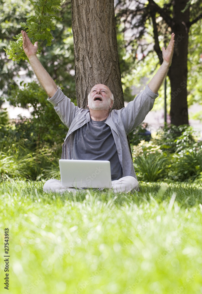 homme âgé connecté en wifi dans l'herbe homme âgé connecté en wifi dans l'herbe