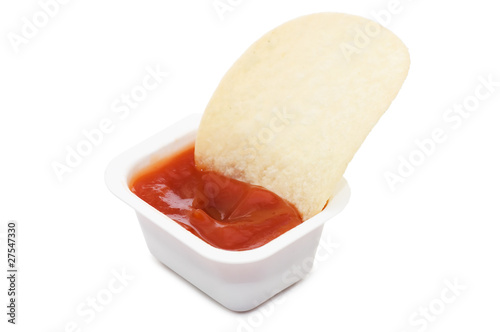 Potato chips in ketchup isolated on white background photo