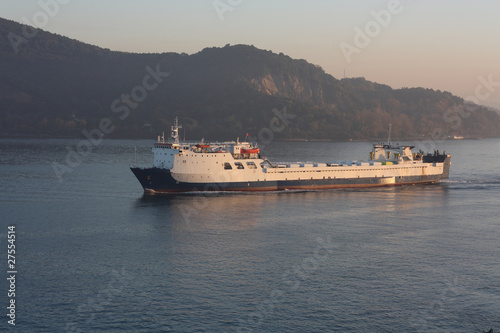 White cargo ship sailing through the Bosphorus in the evening