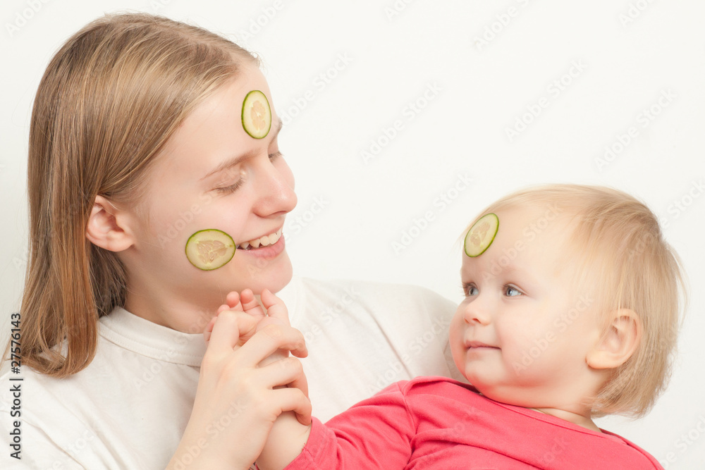 young adorable mother with daughter play with sliced cucumbers o young adorable mother with daughter play with sliced cucumbers o