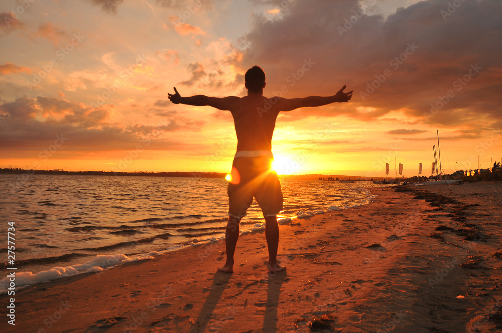 Young man with spread arms celebrating