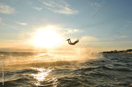 Portrait of a jumping kiteboarder before sunset