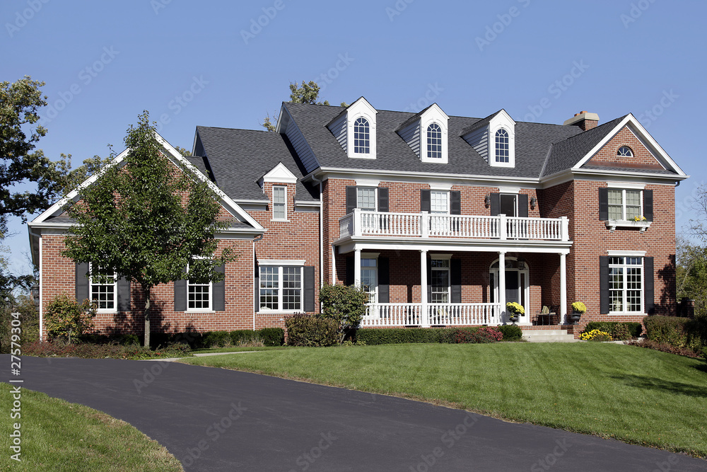 Brick home with front balcony and porch