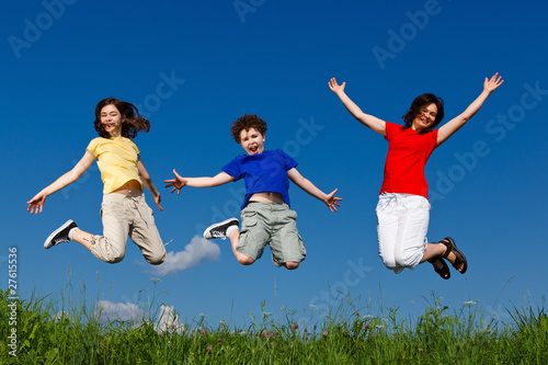 Active family - mother and kids jumping outdoor
