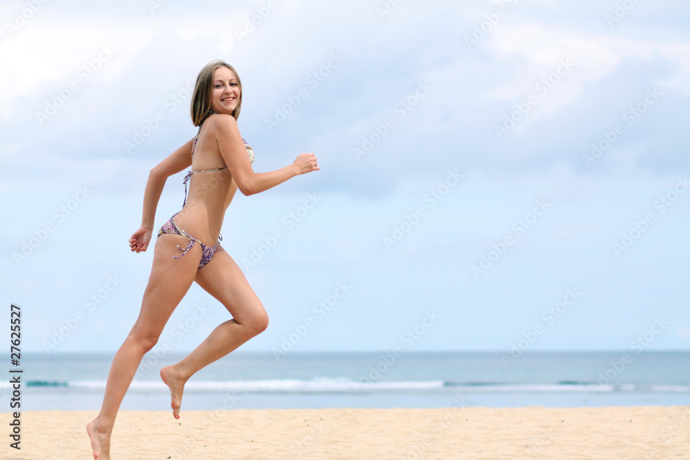 happy woman in bikini walks on a beach