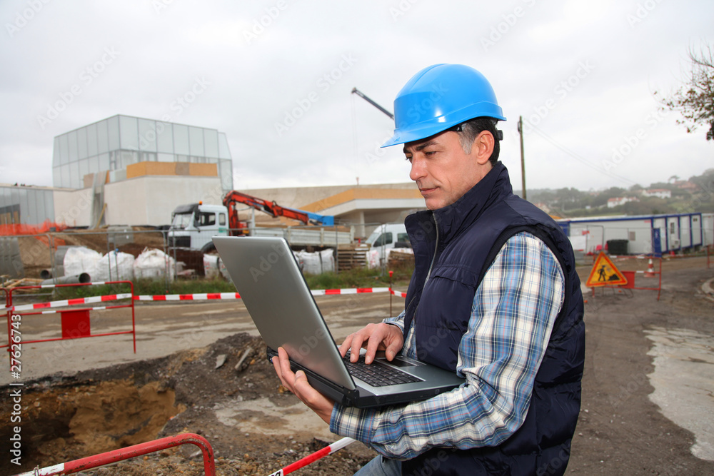 Engineer on construction site with laptop computer