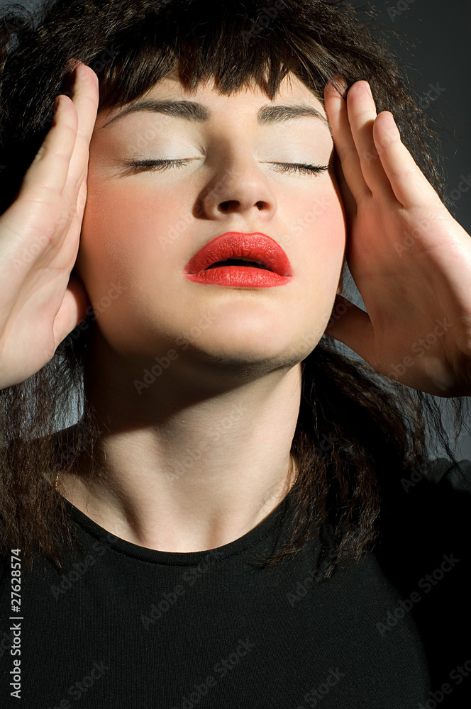 Woman with  headache holding hands to head
