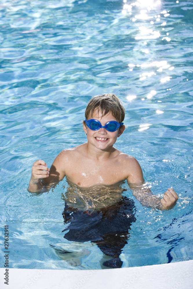 Boy with goggles in swimming pool