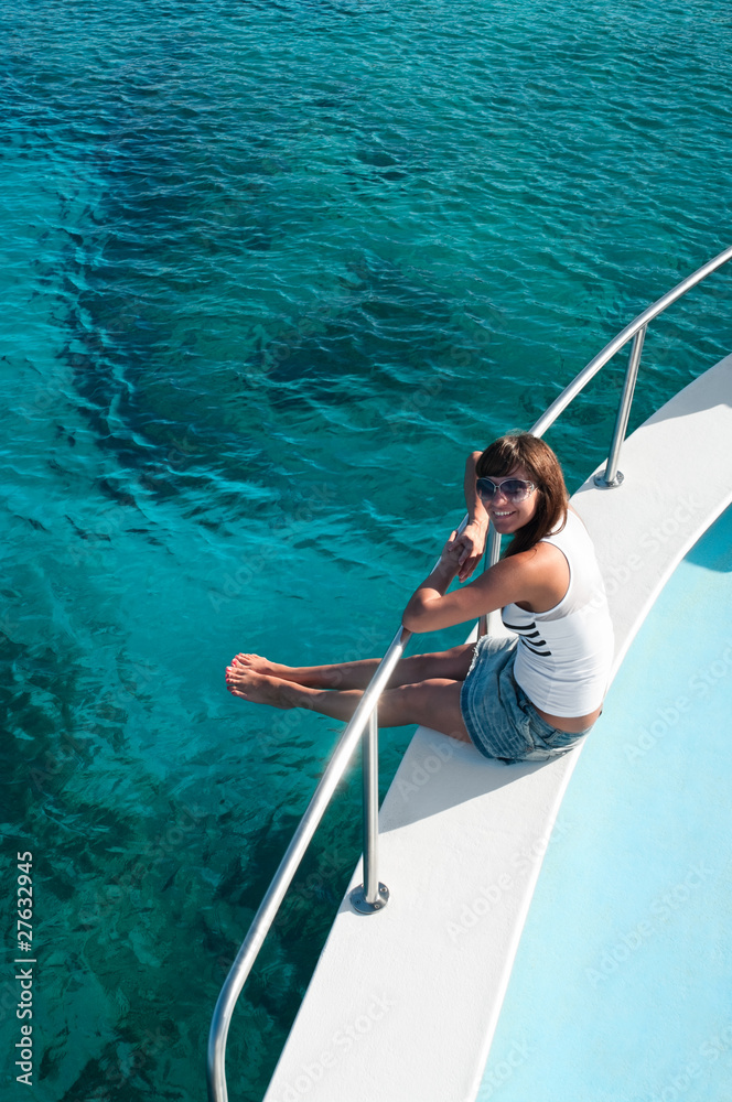 Naklejka premium Woman sitting on edge of yacht