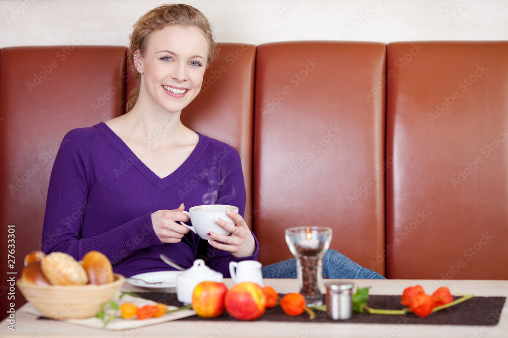 lächelnde frau beim frühstück im café