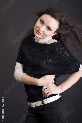Portrait of a young fashionable brunette over black