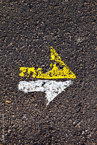 arrow in yellow and white on a paveway for orientation photo