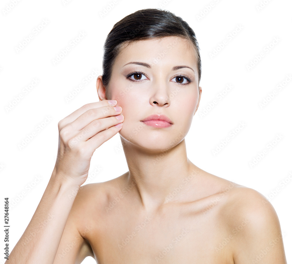 Woman touching  skin on cheek