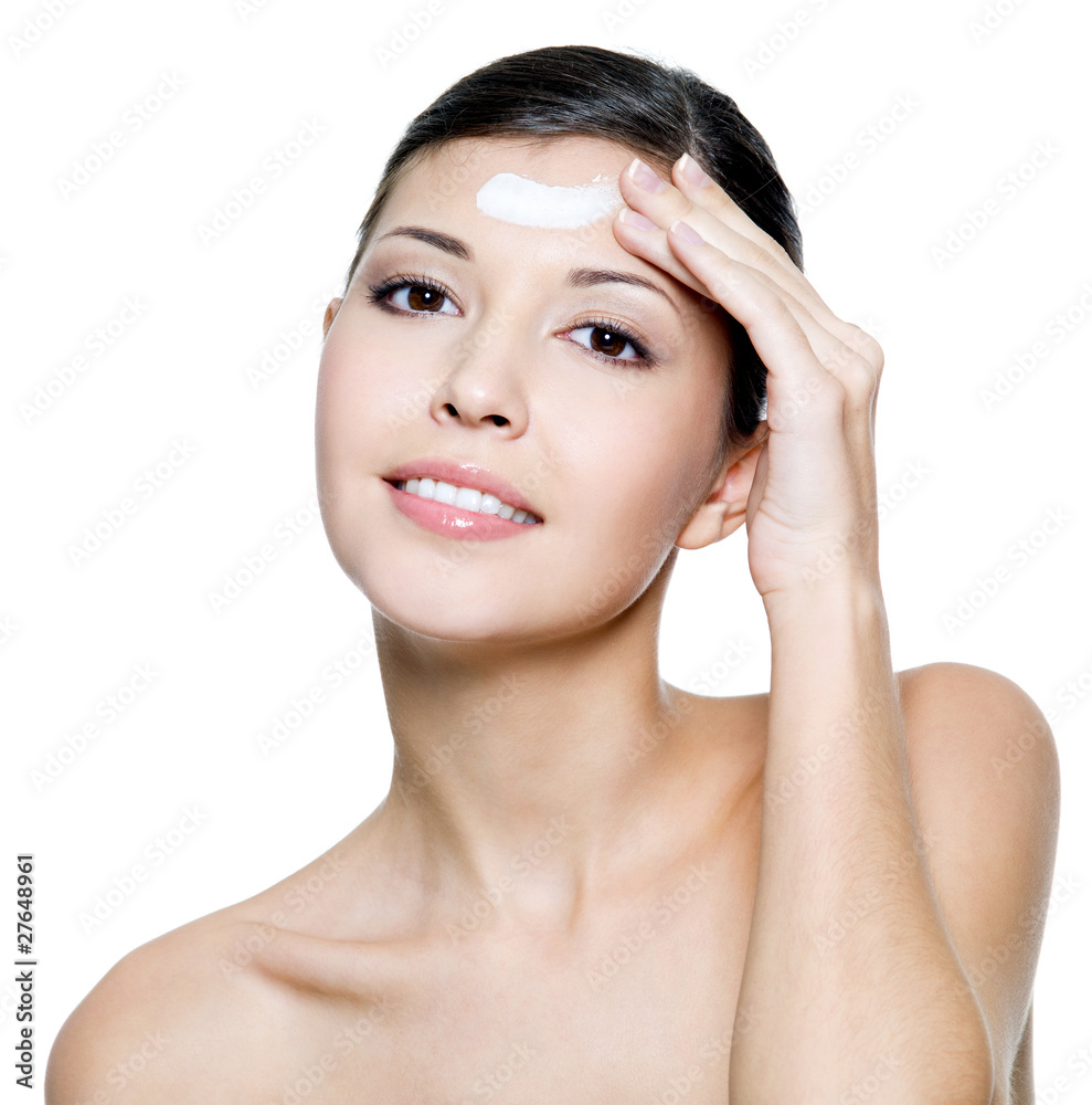 smiling female applying cosmetic cream on forehead smiling female applying cosmetic cream on forehead
