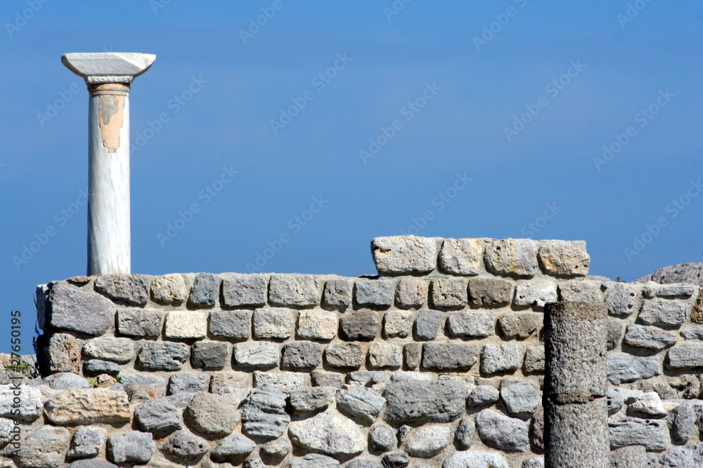 muro di pietre e colonne in un sito archeologico
