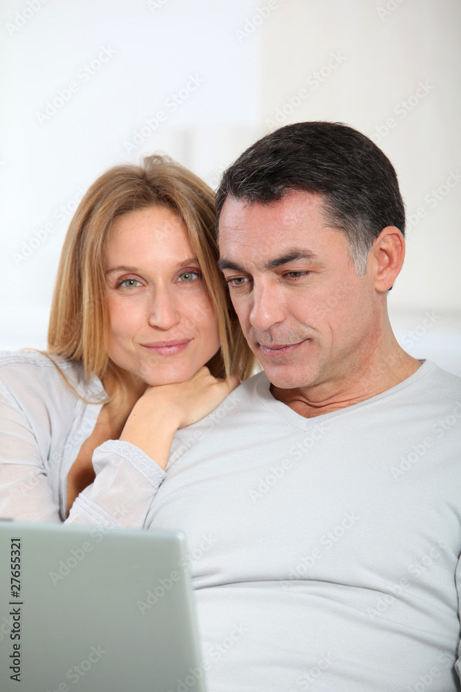 Happy couple surfing on internet at home Happy couple surfing on internet at home