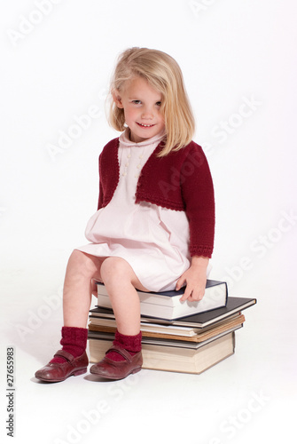Little girl sitting on books