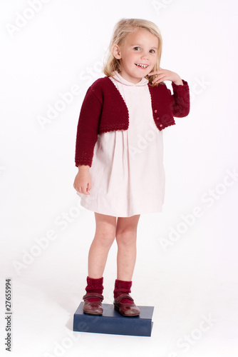 Little girl standing on a book