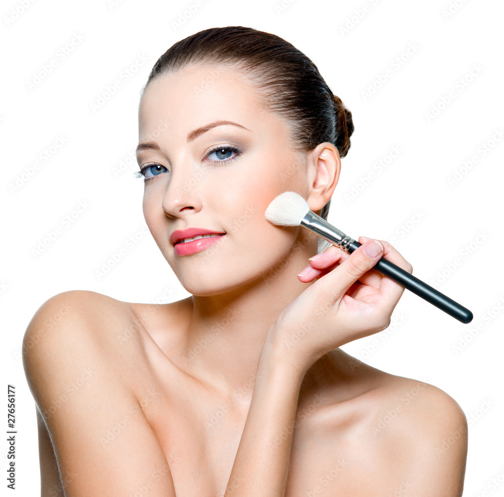 Beautiful woman applying rough on cheek Beautiful woman applying rough on cheek