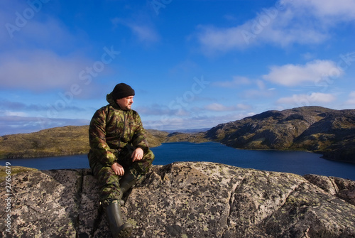 Fotografia Man sits on a mountain top. Ridge Musta Tunturi.