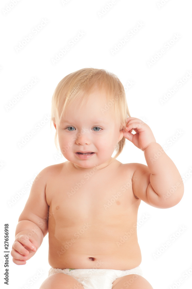 Portrait of disappointed young sitting baby touching ear Portrait of disappointed young sitting baby touching ear