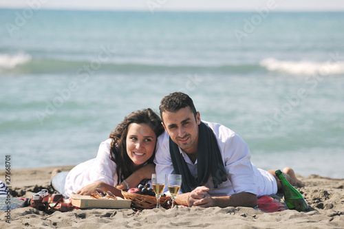 young couple enjoying picnic on the beach