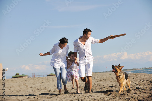 happy family playing with dog on beach © .shock