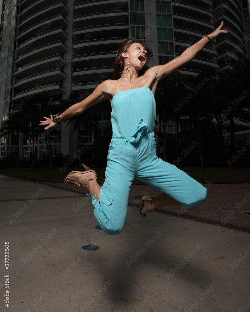 Woman jumping in a blue dress