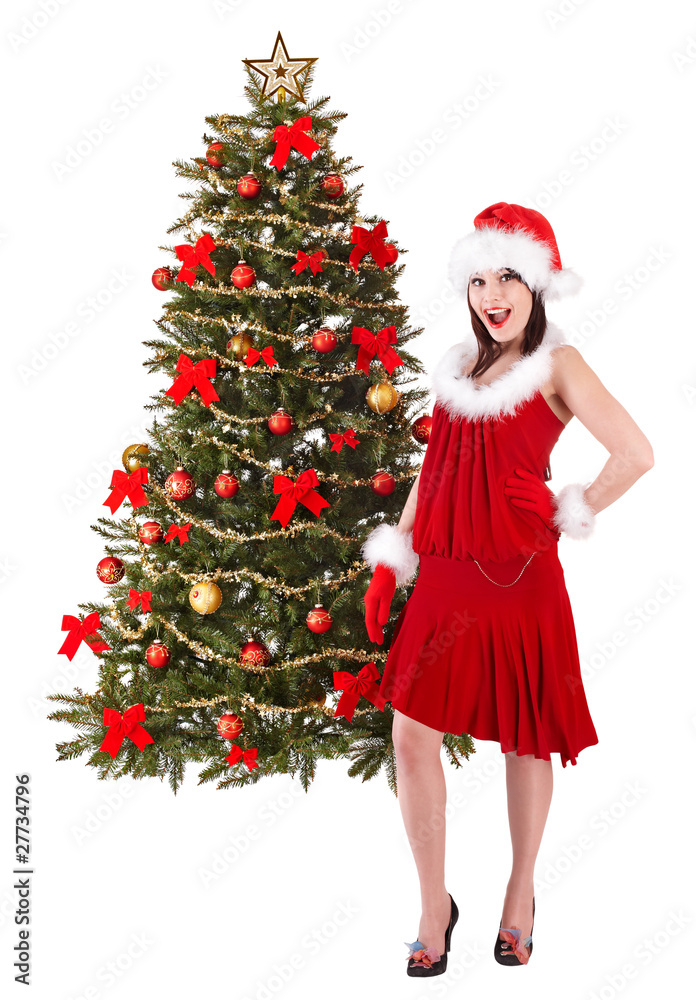 Girl in santa hat by christmas tree. Isolated.