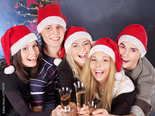 Group young people in santa hat drinking champagne.