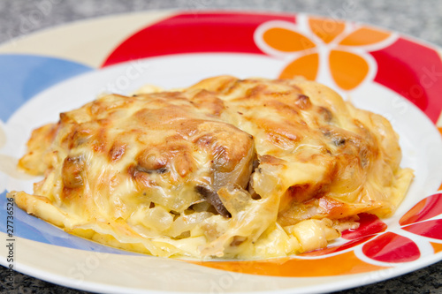 plate with chicken breast baked under cheese